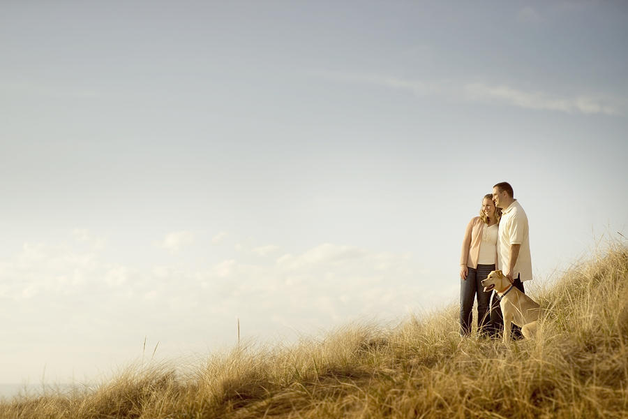 Caucasian couple walking dog on grassy dunes Photograph by Chris Clor