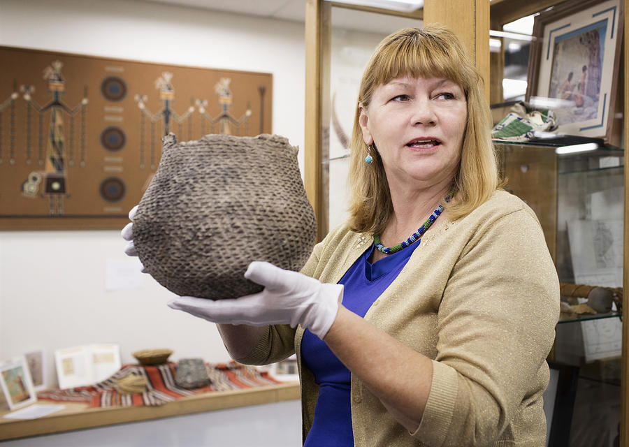 Caucasian curator holding artifact in museum Photograph by Hill Street Studios