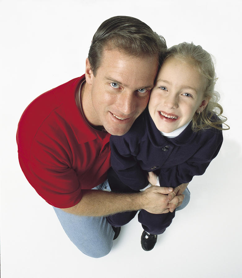 Caucasian Dad On One Knee Holds His Blonde Daughter While Both Smile Big Photograph by Photodisc