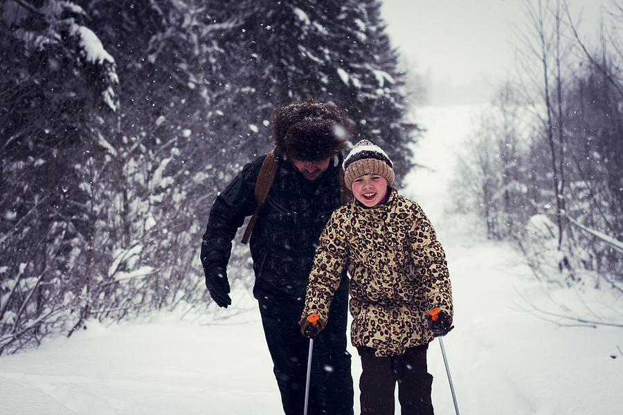 Caucasian father and daughter cross-country skiing on snowy road Photograph by Maxim Chuvashov
