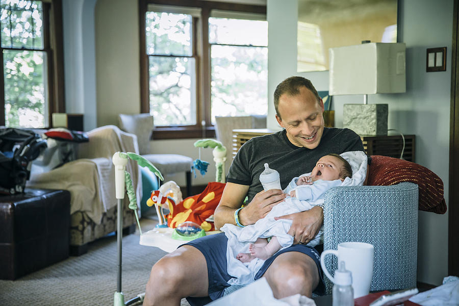 Caucasian father feeding baby boy in living room Photograph by Inti St Clair