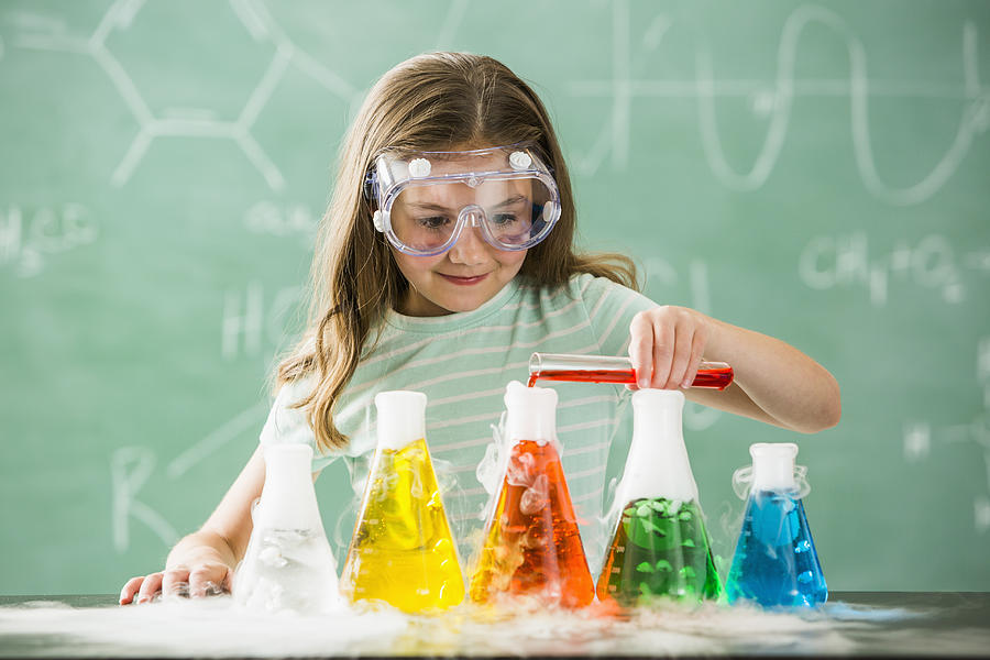 Caucasian girl doing science experiment in classroom Photograph by Mike Kemp