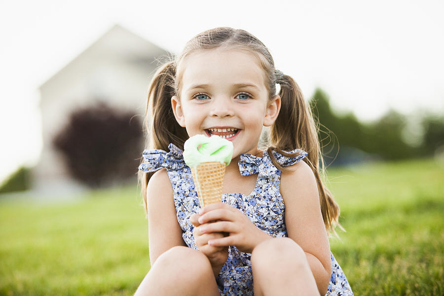 Caucasian girl eating ice cream outdoors Photograph by Mike Kemp