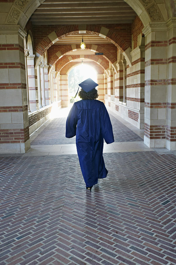 Caucasian graduate walking in portico Photograph by Blend Images - Peathegee Inc