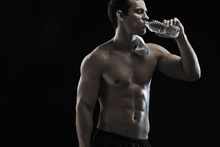 Caucasian man drinking water after exercise Photograph by Blend Images/John Fedele