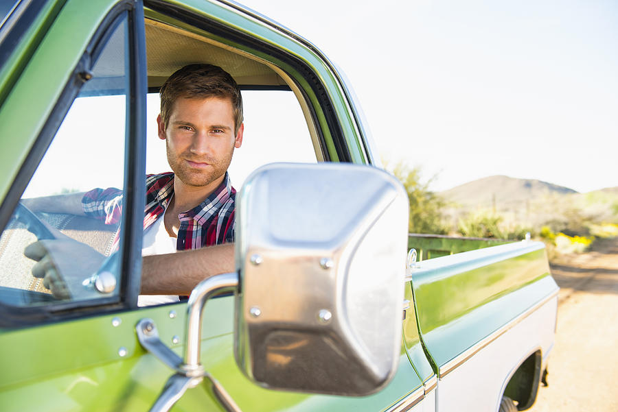 Caucasian man driving truck checking side-view mirror Photograph by Jacobs Stock Photography Ltd