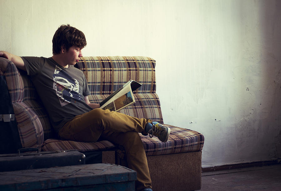 Caucasian man reading in living room Photograph by Maxim Chuvashov