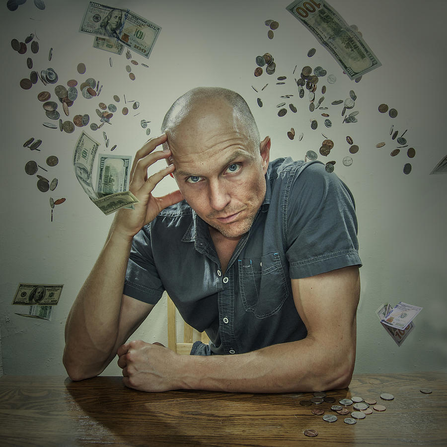 Caucasian man sitting in falling money Photograph by Kirk Marsh