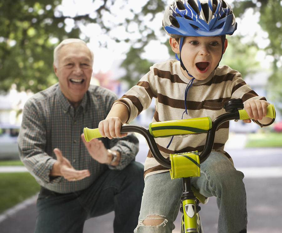 Caucasian man teaching grandson to ride a bicycle Photograph by Jose Luis Pelaez Inc