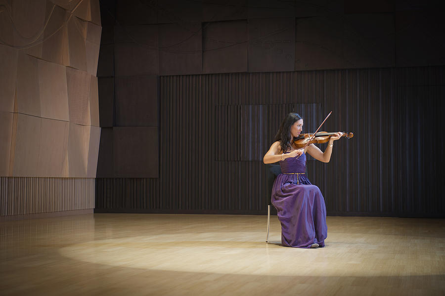 Caucasian musician playing violin on stage Photograph by Jacobs Stock Photography Ltd