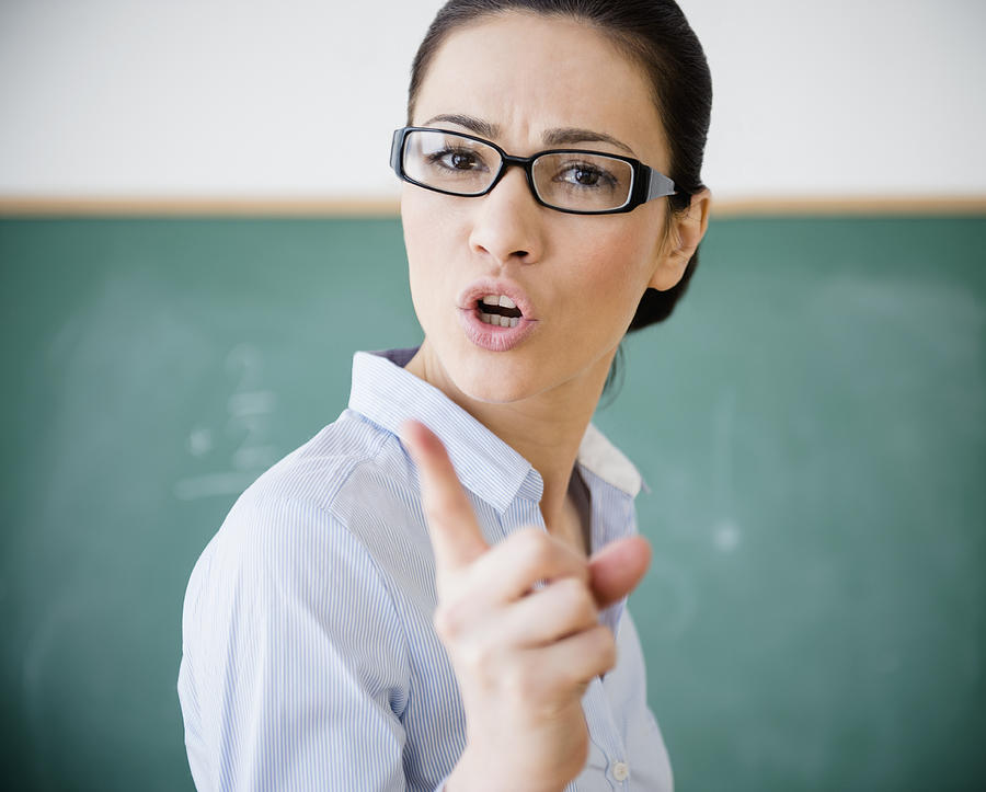 Caucasian teacher scolding in classroom Photograph by JGI/Jamie Grill