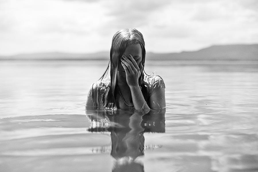 Caucasian teenage girl covering her face in lake Photograph by Vladimir Serov