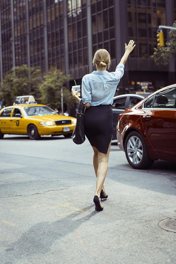 Caucasian woman hailing taxi in urban street Photograph by Hello Lovely