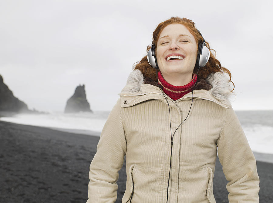Caucasian woman listening to headphones on beach Photograph by Jacobs Stock Photography Ltd