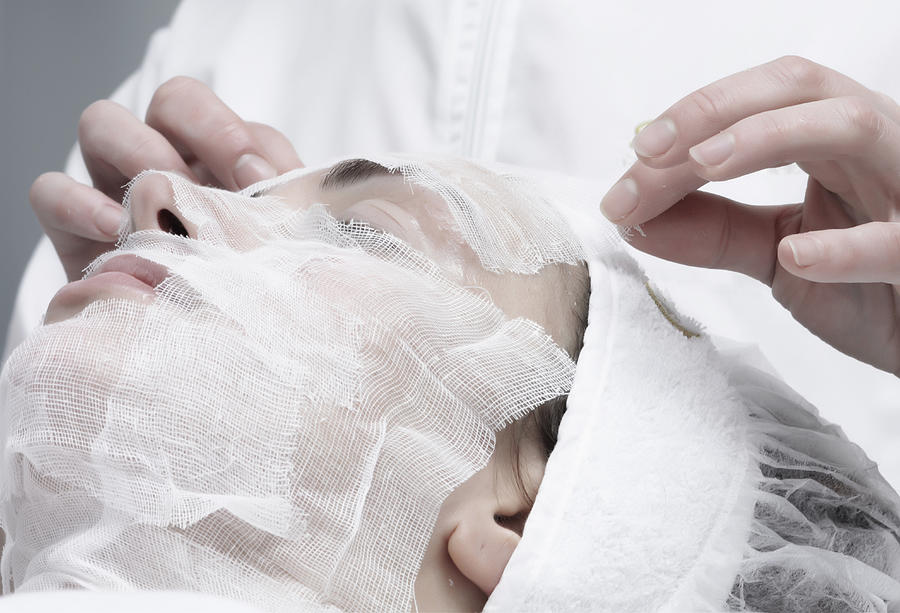 Caucasian woman receiving facial beauty treatment Photograph by Walter Zerla