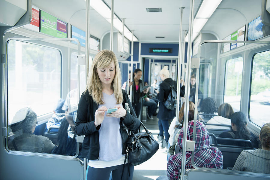 Caucasian woman using cell phone on train Photograph by Jose Luis Pelaez Inc