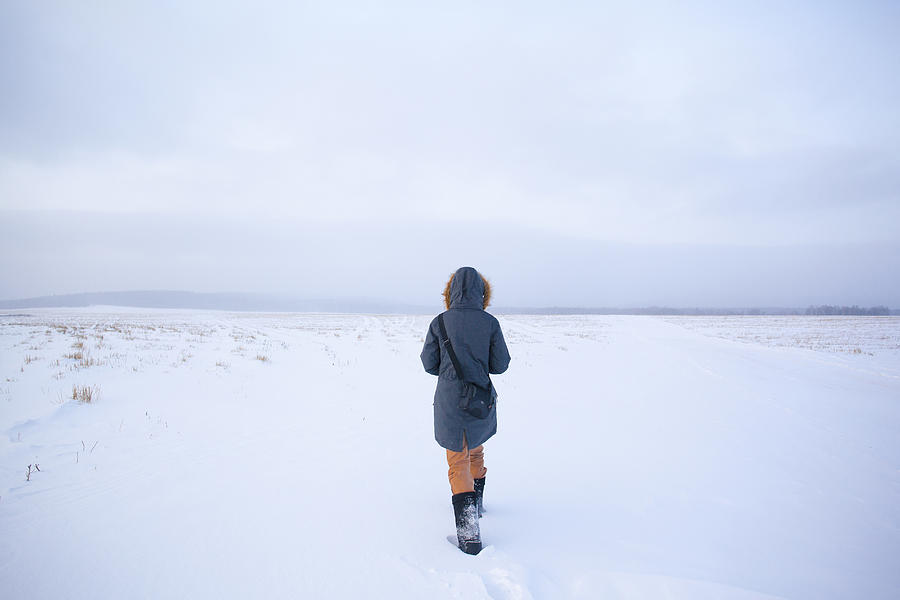 Caucasian woman walking in snowy field Photograph by Aliyev Alexei Sergeevich