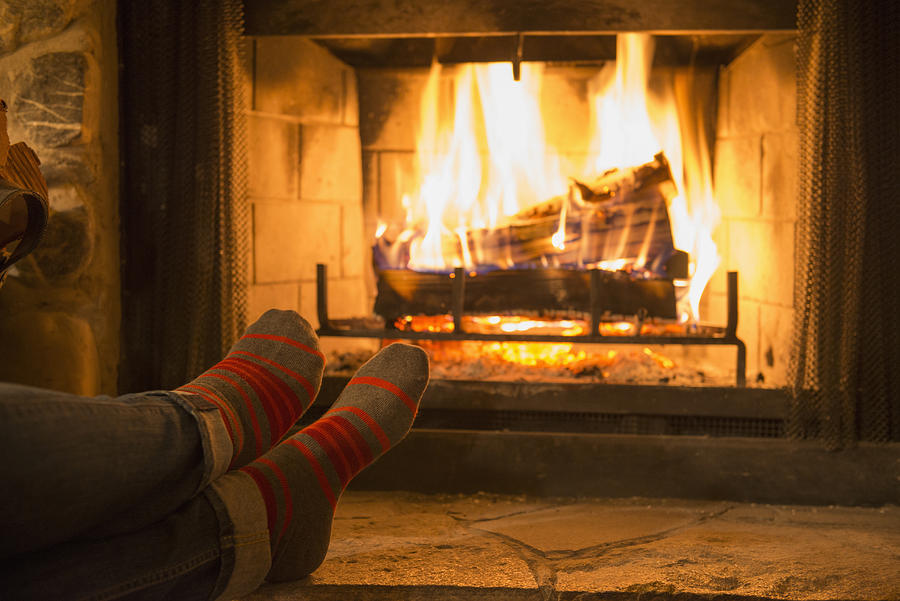 Caucasian woman warming feet near fireplace Photograph by Jacobs Stock Photography Ltd