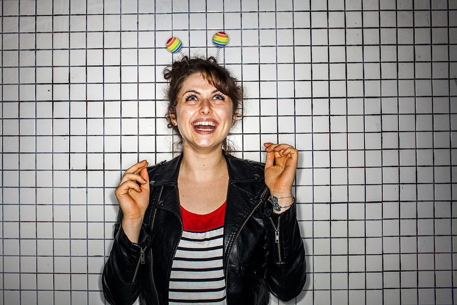Caucasian woman wearing colorful antenna near wall Photograph by Adam Hester
