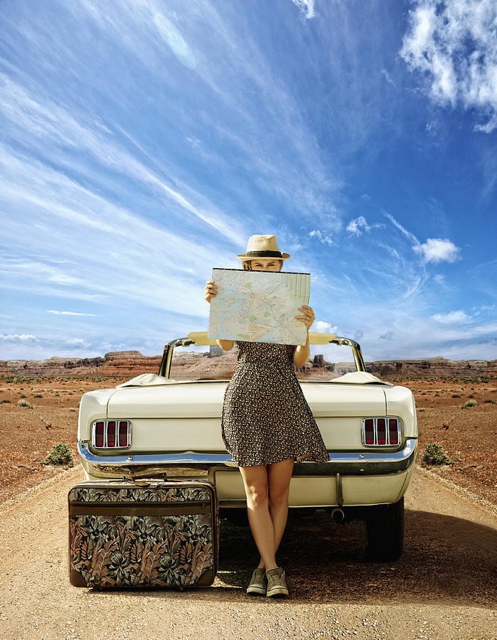 Caucasian woman with convertible reading map on remote road Photograph by Colin Anderson Productions pty ltd