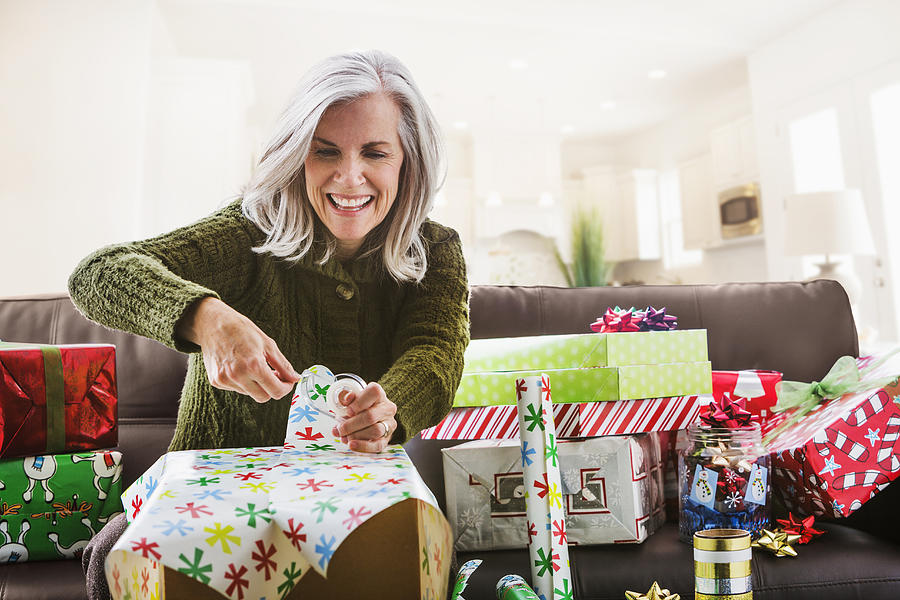 Caucasian woman wrapping Christmas gifts Photograph by Mike Kemp