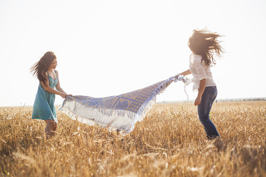 Caucasian women spreading blanket in rural field Photograph by Aliyev Alexei Sergeevich