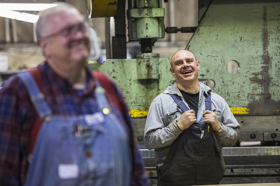 Caucasian workers laughing in factory Photograph by Jetta Productions Inc