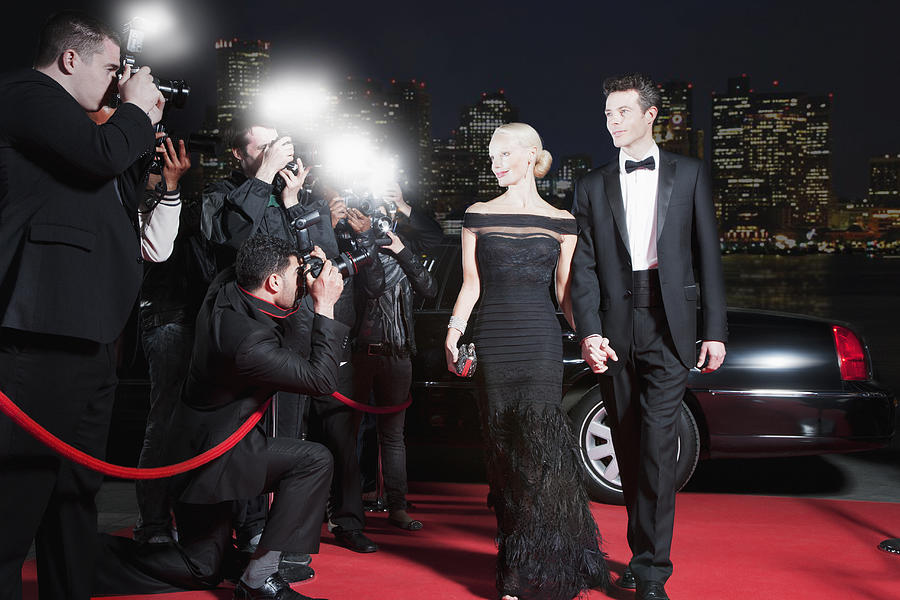 Celebrities posing for paparazzi on red carpet Photograph by Robert Daly