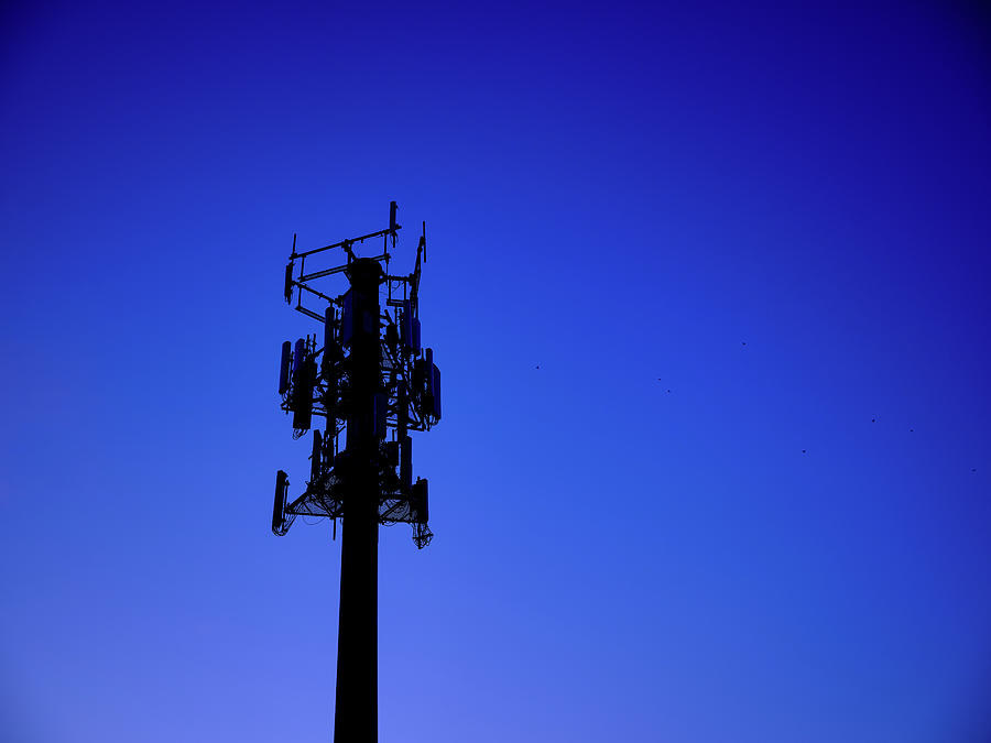 Cell phone radio tower at sunset as a silhouette Photograph by Jorge Moro