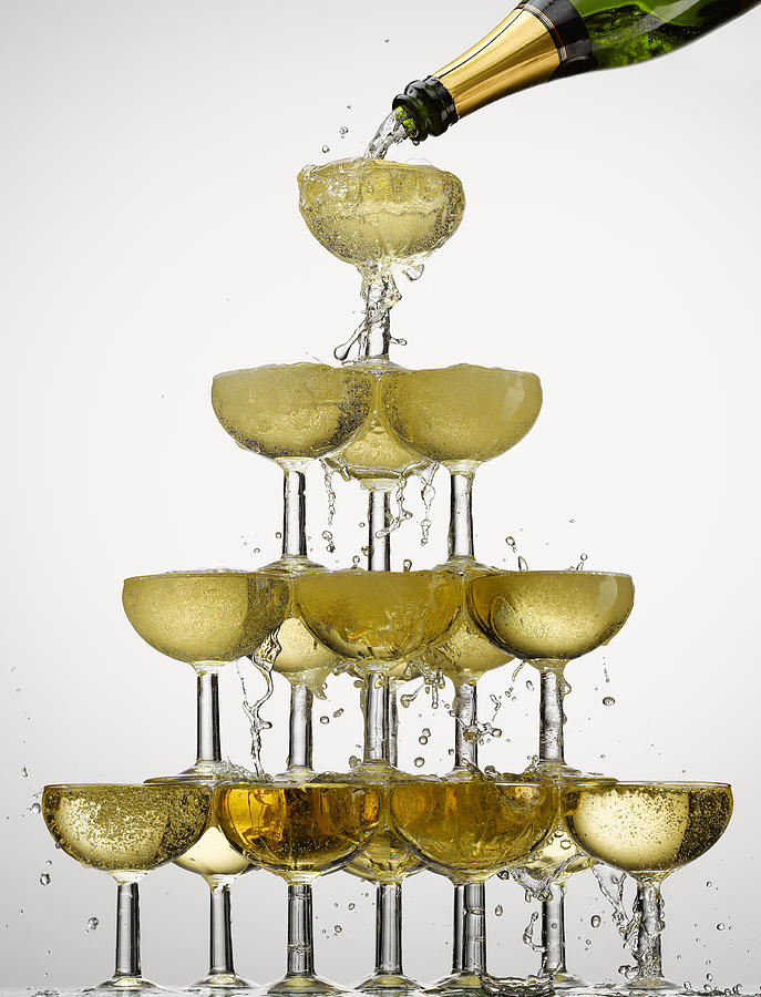 Champagne pouring into stacked glasses Photograph by Andy Roberts