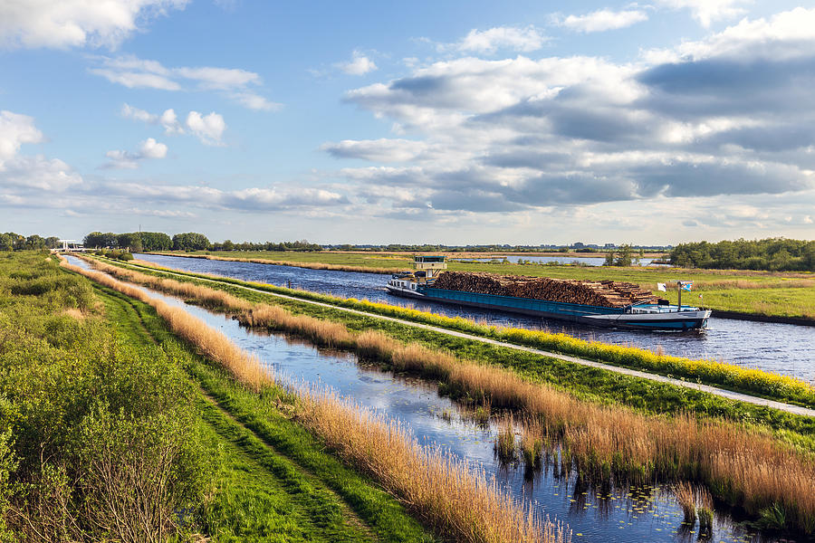 Channel with freighter with wood Photograph by Dutchphotography Channel with freighter with wood Photograph by Dutchphotography
