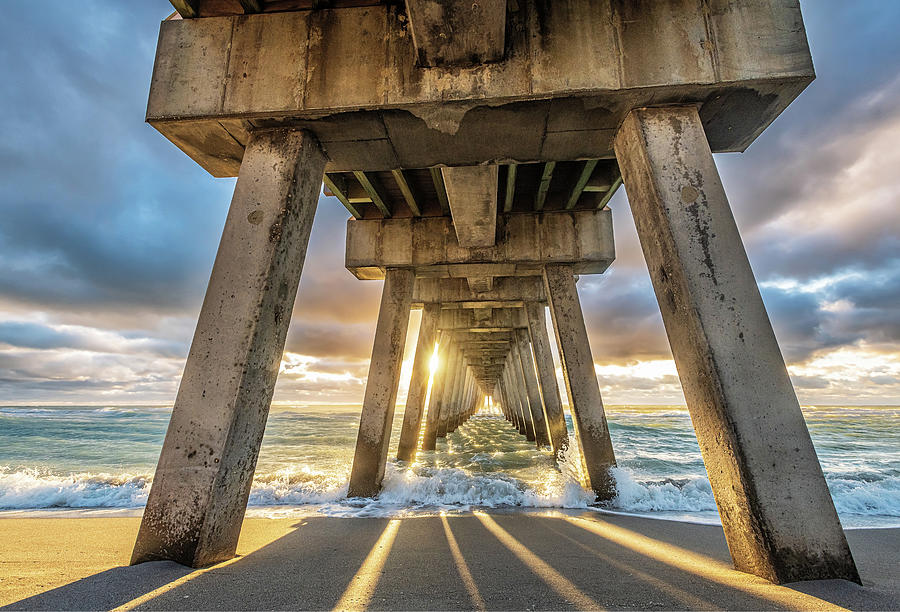 Chasing the light under the Pier Photograph by Rudy Wilms
