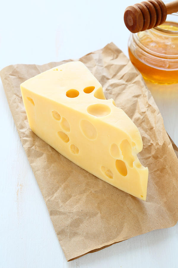 Cheddar cheese on a paper with honey Photograph by Olha_Afanasieva