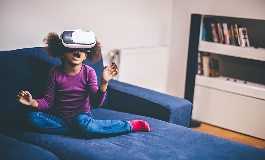 Cheerful girl with virtual reality goggles Photograph by Pekic