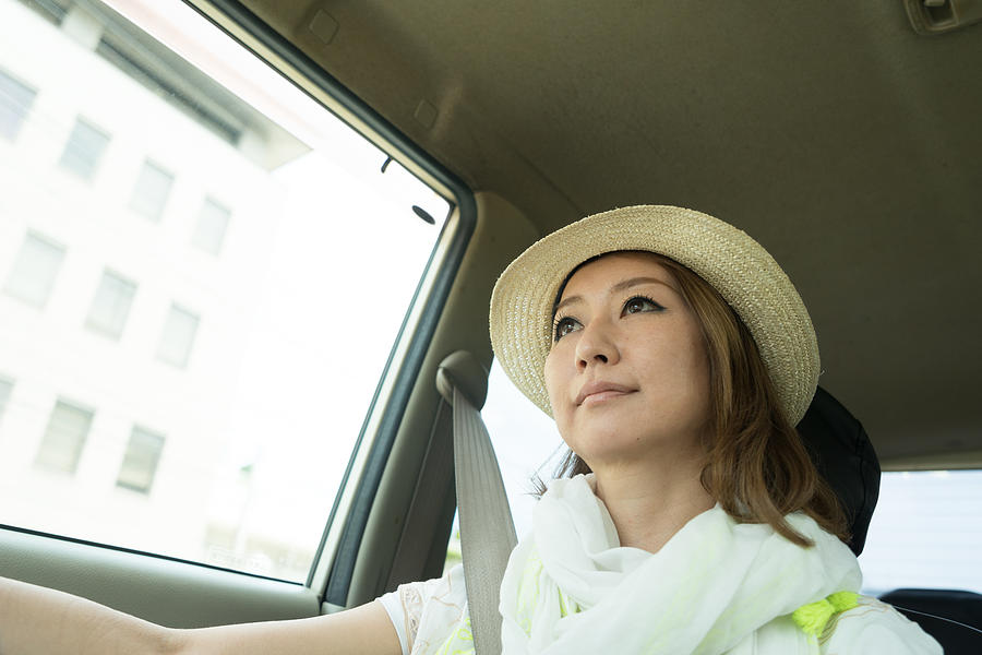 Cheerful Japanese woman driving car wearing Photograph by Rossella De Berti