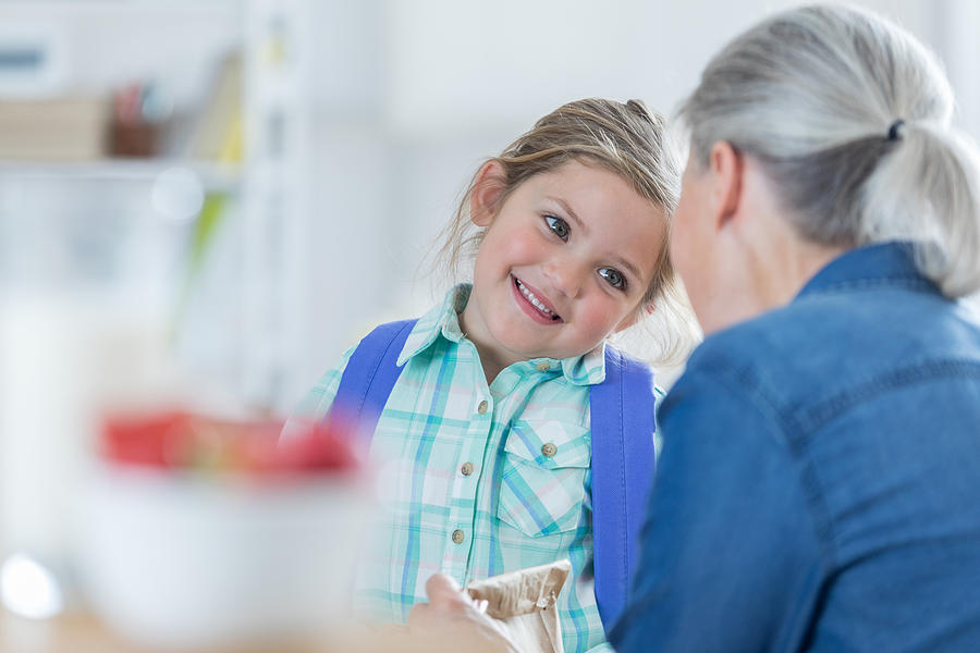 Cheerful little girl talks with grandma before school Photograph by SDI Productions