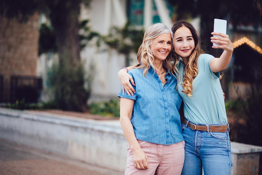 Cheerful mother and daughter taking selfies together in the city Photograph by Wundervisuals
