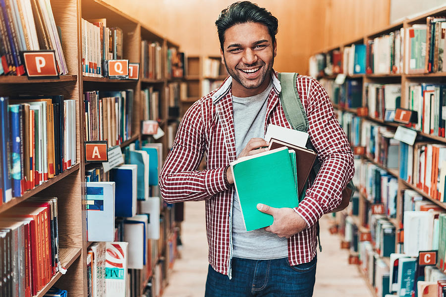 Cheerful student with bunch of books Photograph by Pixelfit
