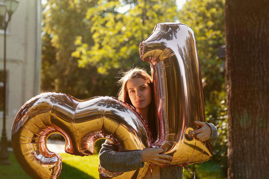 Cheerful woman celebrates a thirty one years birthday with big golden balloons Photograph by Anastasia Dobrusina
