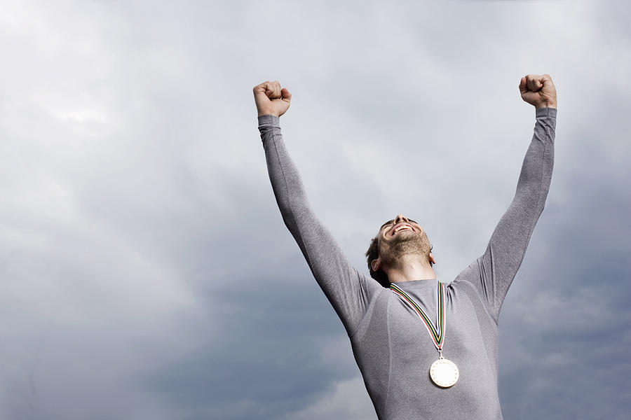 Cheering runner wearing medal Photograph by Robin Skjoldborg