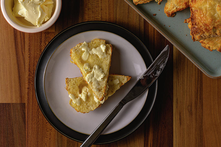 Cheese scone top down with butter Photograph by Scott Lyons