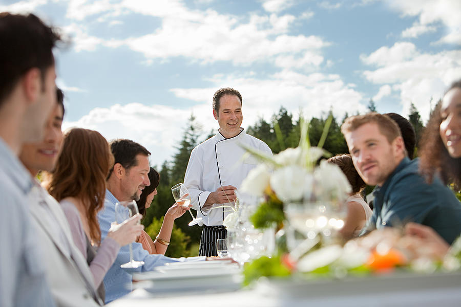 Chef and people at outdoor dinner party Photograph by Image Source