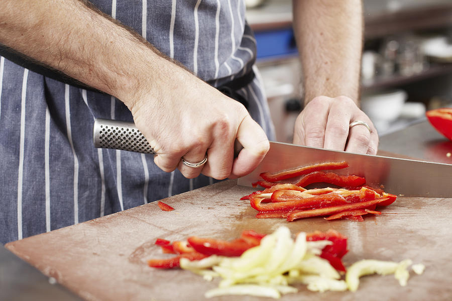 Chef chopping vegetables in kitchen Photograph by Photo_Concepts