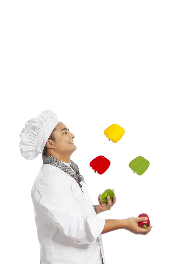 Chef juggling capsicum Photograph by IndiaPix/IndiaPicture