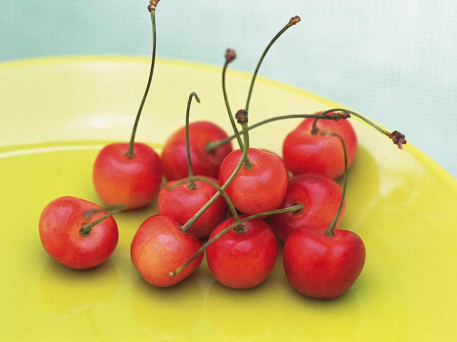 Cherries on yellow plate, High angle view Photograph by Daj