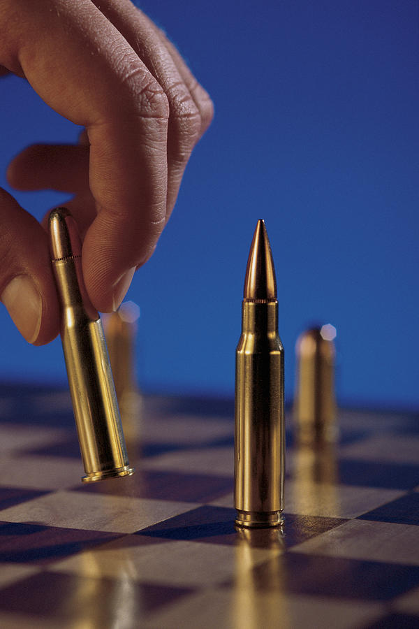 Chess board with bullets Photograph by Comstock