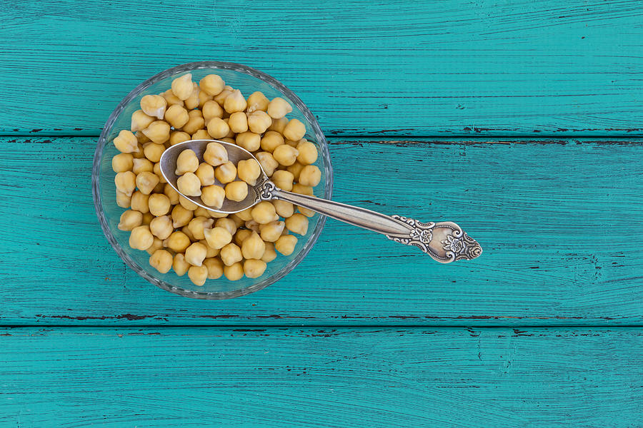 Chick peas on a wood background Photograph by Vlad Fishman