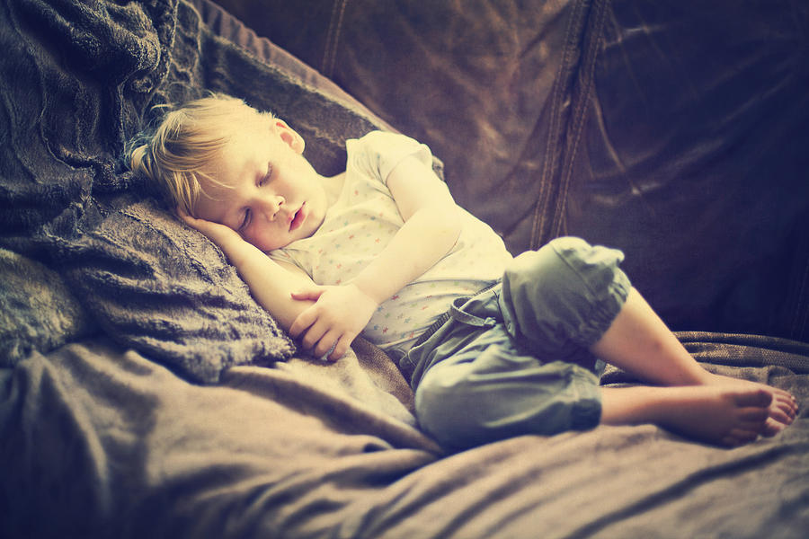 Child asleep on sofa Photograph by Sally Anscombe