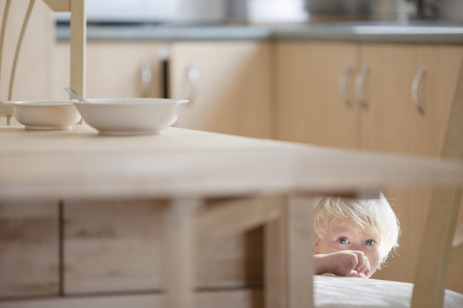 Child Hiding Under Kitchen Table Photograph by Kent Mathews