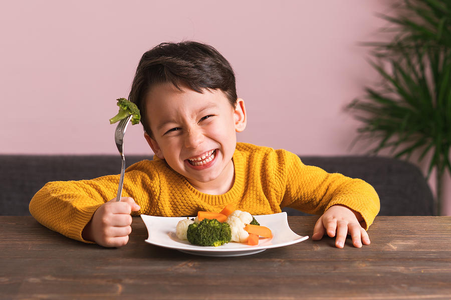 Child is eating vegetables. Photograph by Pinstock